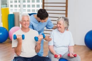 Female instructor with senior couple in gym