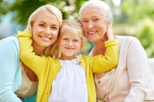 family, 3 generations - happy smiling woman with daughter and senior mother sitting on park bench