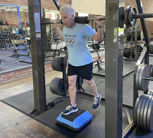 senior man doing barbell exercise in gym